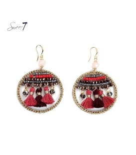 Rood gekleurde oorbellen in de hanger zijn kralen en kwasten verwerkt