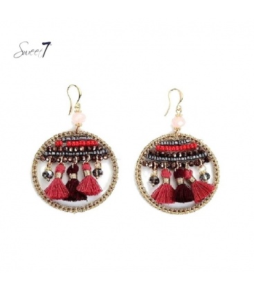 Rood gekleurde oorbellen in de hanger zijn kralen en kwasten verwerkt