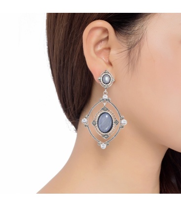 Zilverkleurige oorclips met een grijze resin hanger en strass steentjes