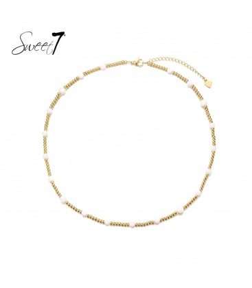 Goudkleurige korte halsketting met witte glas kralen