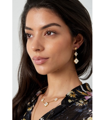 Zilverkleurige oorhangers in de vorm van 2 groten bloemen en een hartje als oorstukje