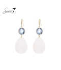 Witte schelpen oorhangers met een blauw glas steentje