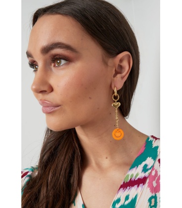 Goudkleurige oorhangers met een hartje en een fuchsia roze smiley