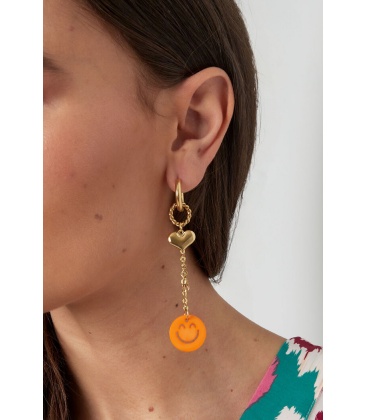 Goudkleurige oorhangers met een hartje en een fuchsia roze smiley