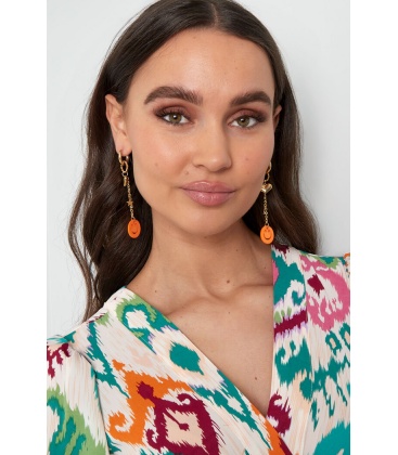 Goudkleurige oorhangers met een hartje en een fuchsia roze smiley