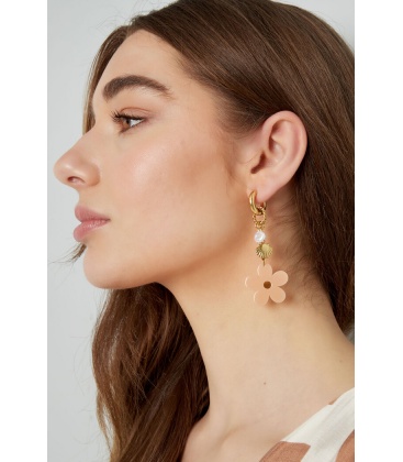 Goudkleurige oorhangers met een beige bloem en bedels