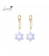 Goudkleurige oorringen met een paarse bloemen hanger en parel