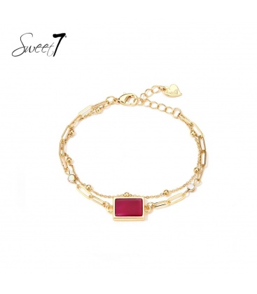 Goudkleurige armband met een fijn kettinkje en rode steen