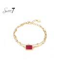 Goudkleurige armband met een fijn kettinkje en rode steen