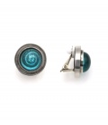 Oorclips met turquoise spiraal en bol glasdesign en een zilverkleurige rand