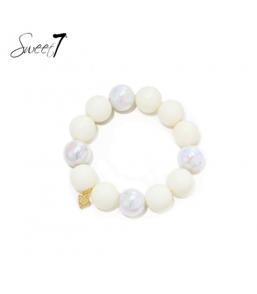 Armband met witte kralen en een goudkleurig hartje
