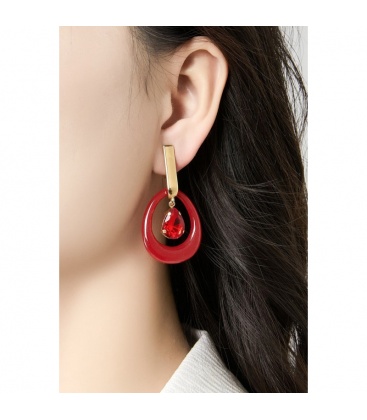 Oorclips met rode hanger en een glas steen met een goudkleurig detail