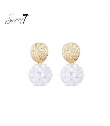 Oorbellen met goudkleurige schijf en witte kralenbol.