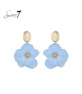 Oorbellen met blauwe bloemen en goudkleurige accenten.
