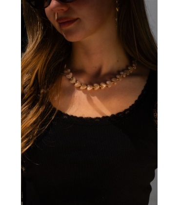 Halsketting met creme kleurige hartjes en goudkleurige accenten