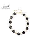 Halsketting met zwarte polkadot schakels en goudkleurige ringen